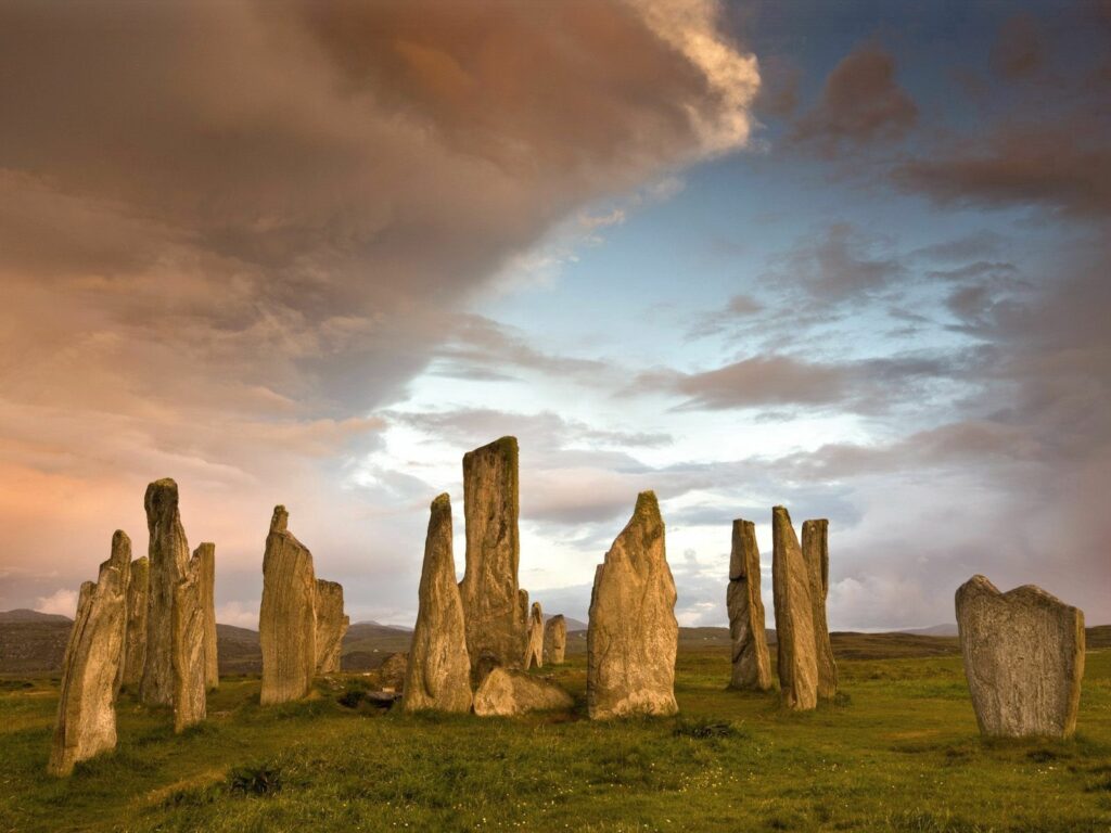 Ancient stone blocks at sunset under dramatic sky with warm clouds mountain landscape wallpaper