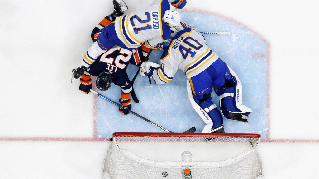 Anders Lee scores goal versus Buffalo Sabres with goalie and defenders defending crease action Wallpaper