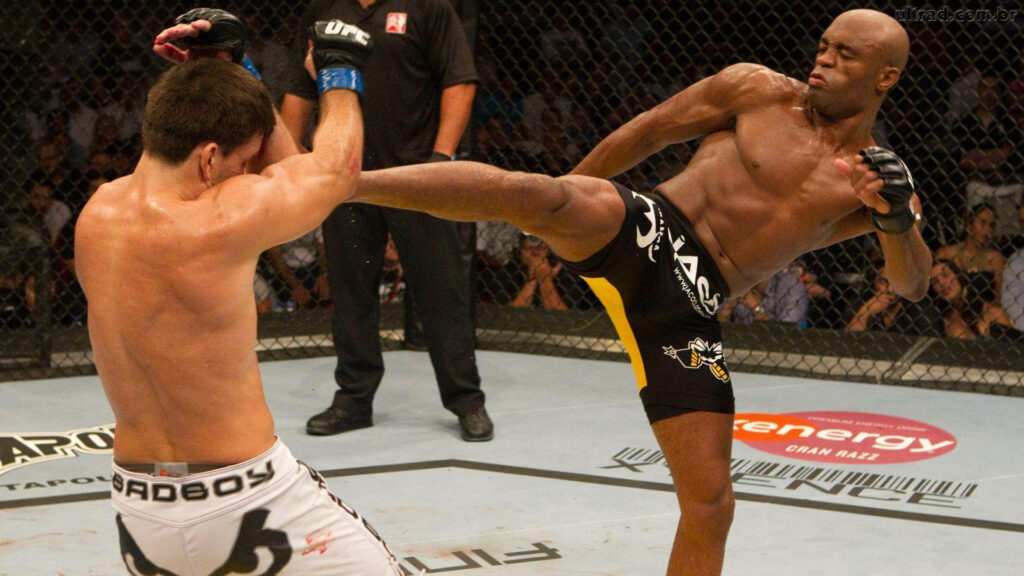 Anderson Silva delivers a powerful kick to opponent inside UFC octagon intense action wallpaper