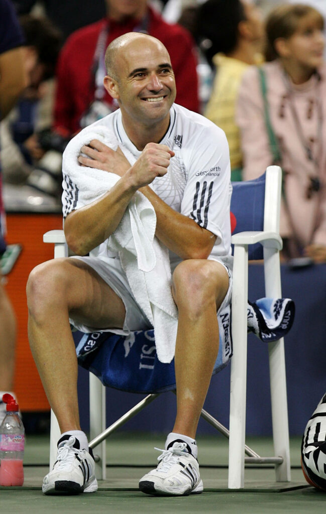 Cheerful Andre Agassi Wallpaper: Relaxed Moment on a Tennis Court