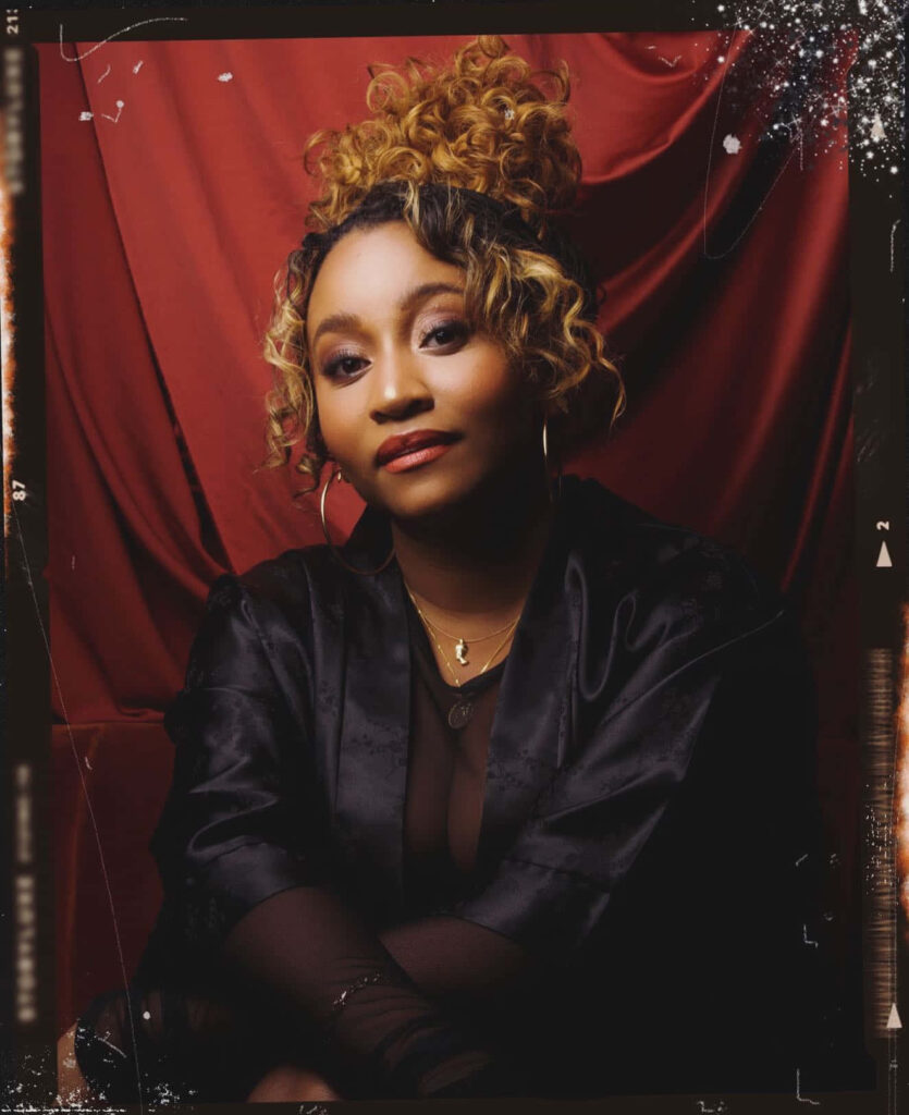 Andrea Lewis elegant portrait confident pose dramatic red wallpaper background sophistication