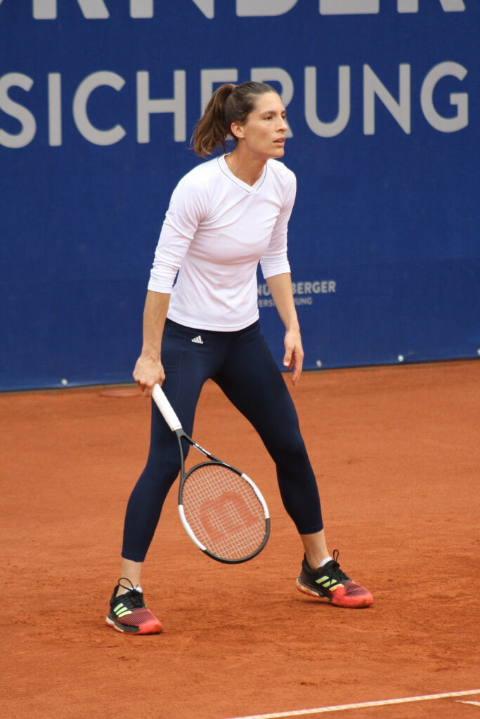Andrea Petkovic focused on clay tennis court wearing athletic gear holding racket determined athlete Wallpaper