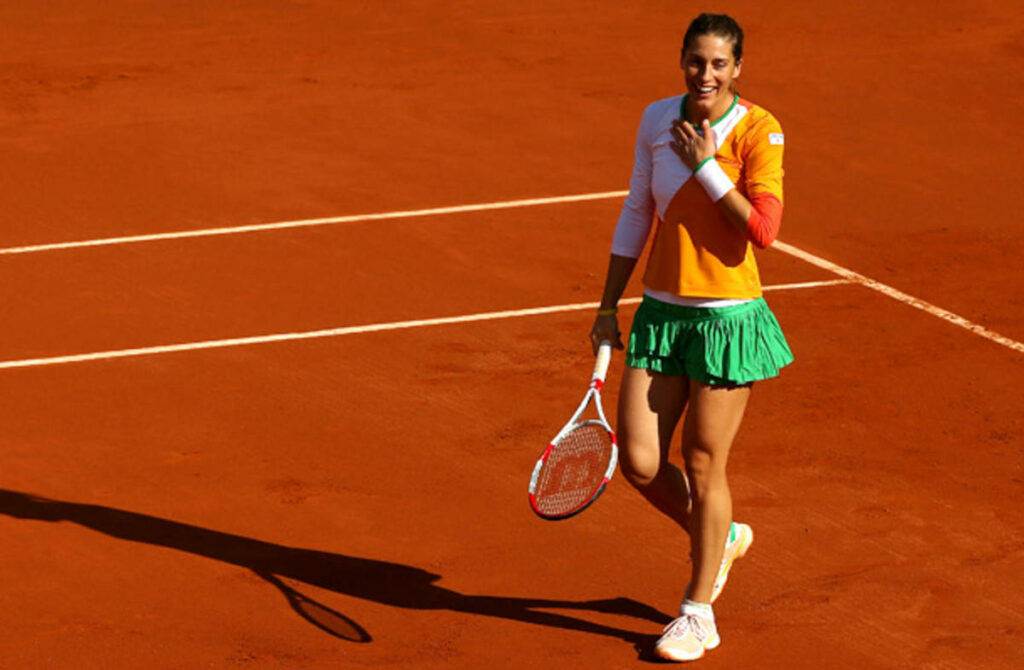 Andrea Petkovic smiling on red clay court holding tennis racquet during 2014 French Open tournament Wallpaper