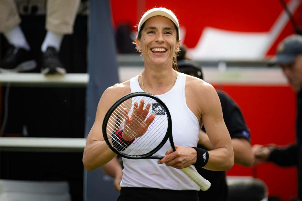 Andrea Petkovic smiling on tennis court holding racquet dynamic WTA Titlist wallpaper background