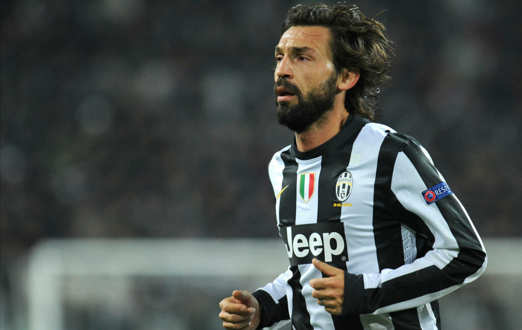 Andrea Pirlo in Juventus jersey skillfully dribbling during a football match wallpaper background