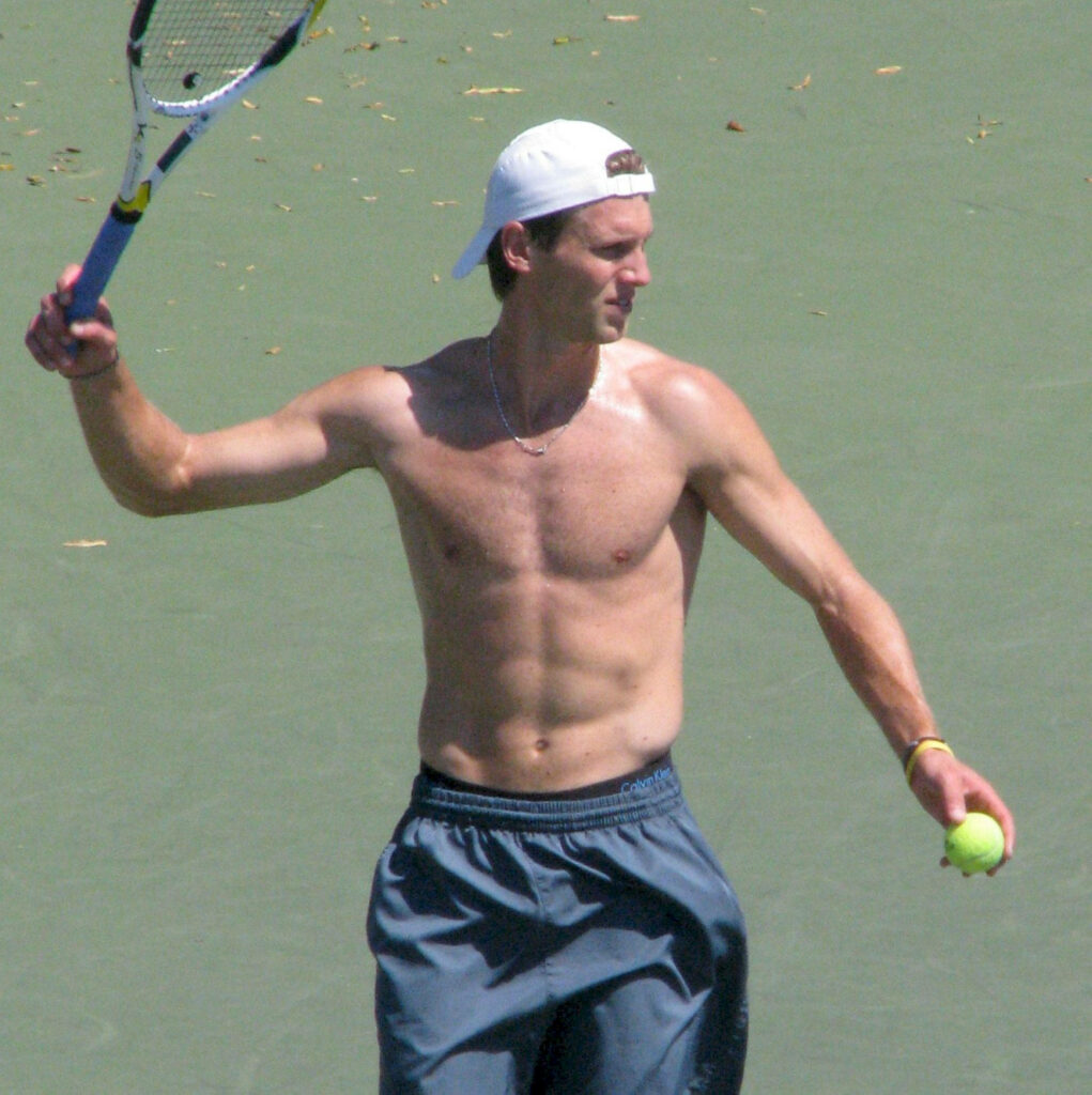 Andreas Seppi shirtless on tennis court holding racket and ball showcasing athletic physique Wallpaper