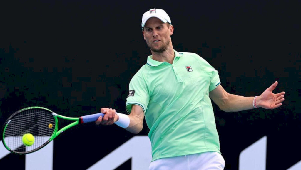 Andreas Seppi in green shirt focused returning tennis shot during intense match with wallpaper background