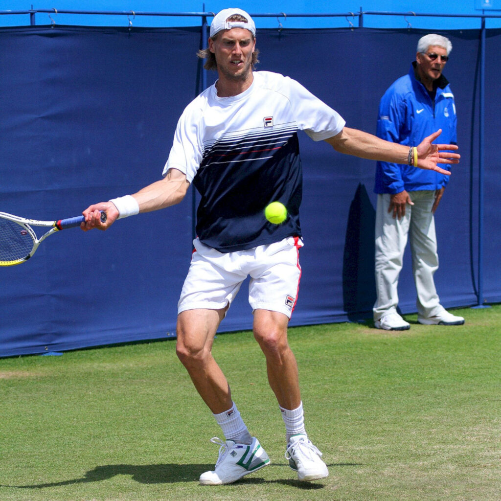 Andreas Seppi intense return on grass tennis court showing athletic form and focus in match Wallpaper