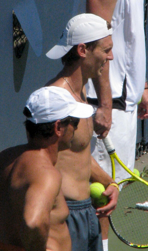 Andreas Seppi shirtless holding tennis ball with players on court ready for practice wallpaper background