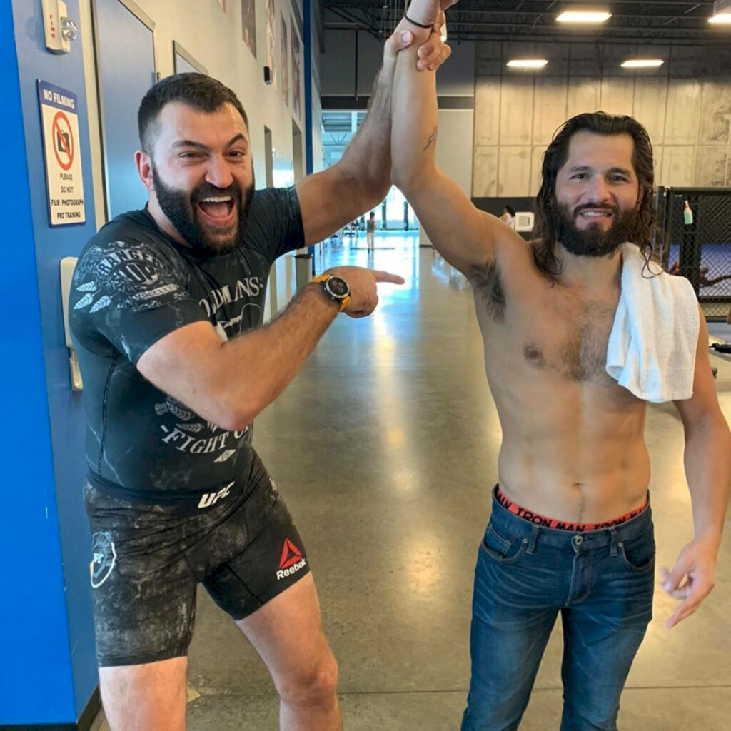Andrei Arlovski celebrates energetic victory with friend in lively gym motivational wallpaper background