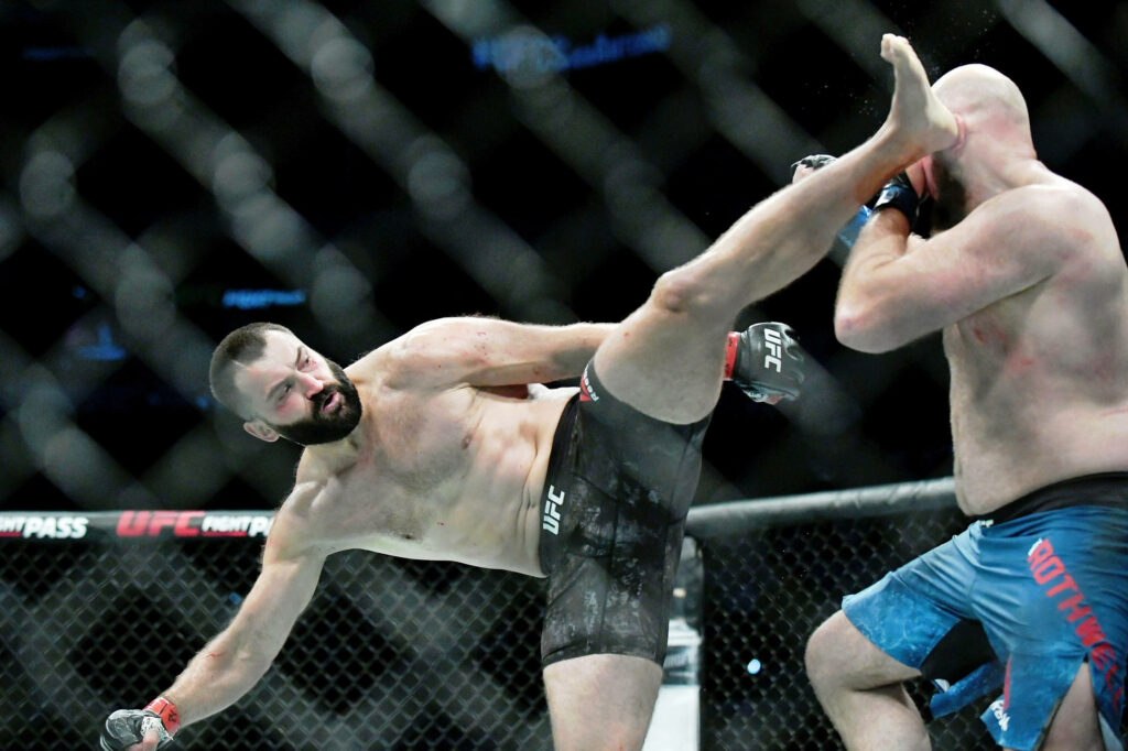 Andrei Arlovski lands a powerful UFC 271 kick in London octagon fight action wallpaper background