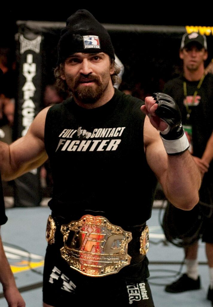 Andrei Arlovski UFC heavyweight champion posing in octagon with championship belt and MMA gear Wallpaper
