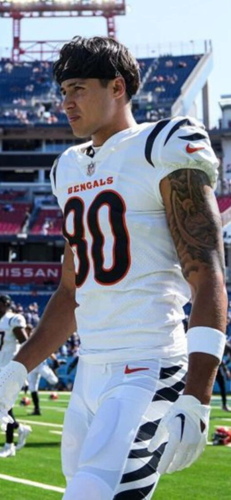 Andrei Iosivas in Bengals number 80 uniform making a dynamic play on football field game day Wallpaper