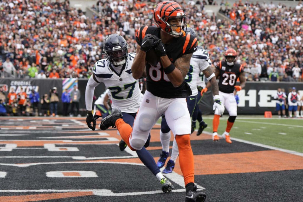 Andrei Iosivas leaps for dynamic football catch in end zone showcasing intense game action Wallpaper
