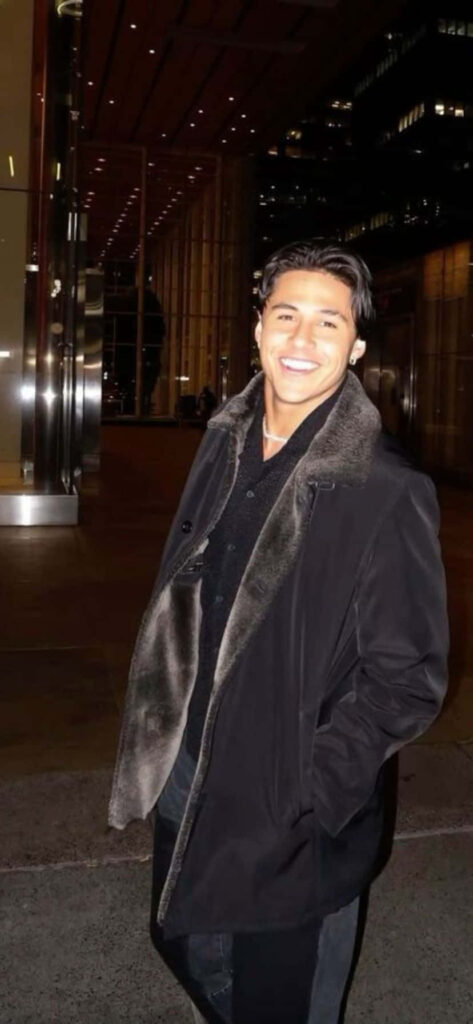 Andrei Iosivas smiling in front of modern evening cityscape vibrant wallpaper background