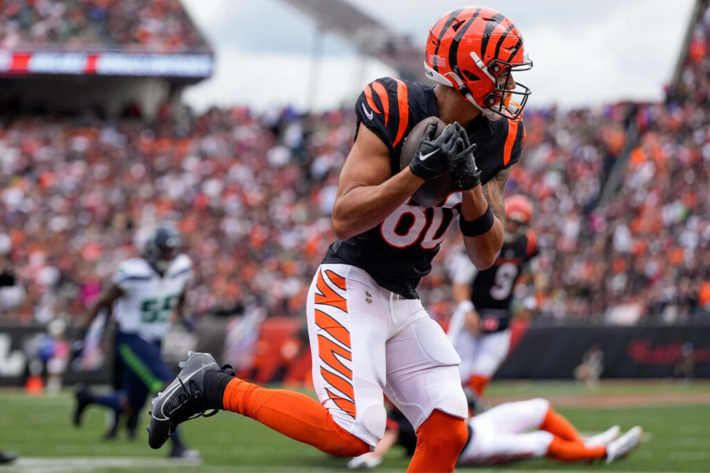 Andrei Iosivas sprinting with football in Cincinnati Bengals uniform during intense game action Wallpaper