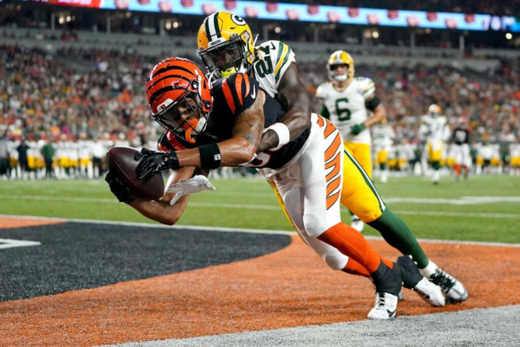 Andrei Iosivas leaping for a thrilling touchdown catch in a high intensity football game action Wallpaper