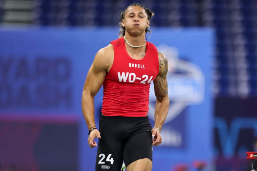 Andrei Iosivas focused in red top and black shorts dynamic sports wallpaper background