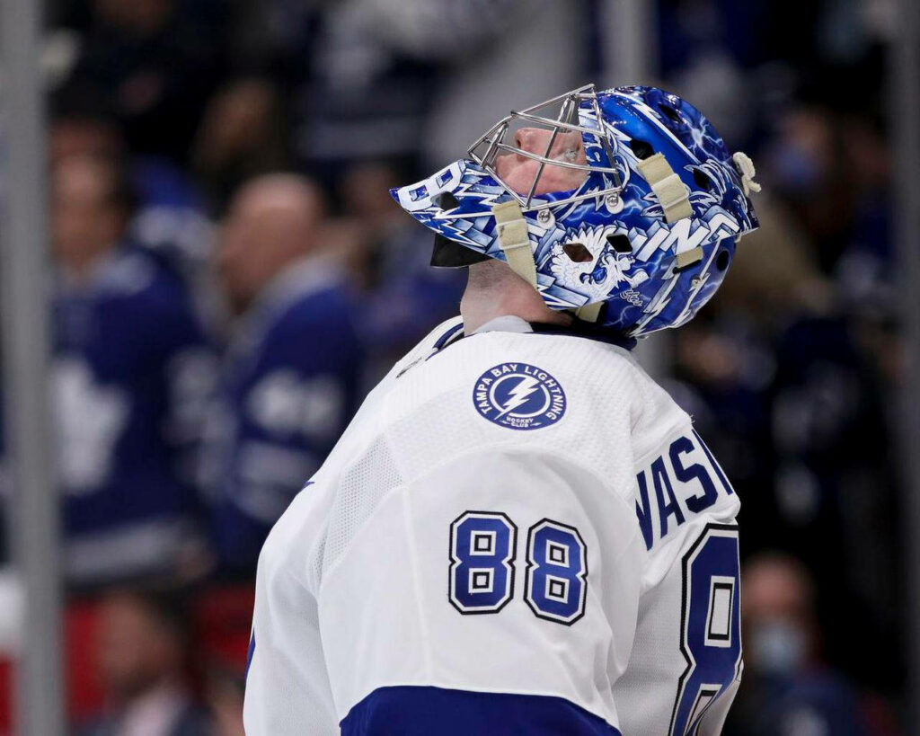 Andrei Vasilevskiy in Tampa Bay Lightning jersey and mask focused on the ice rink background Wallpaper