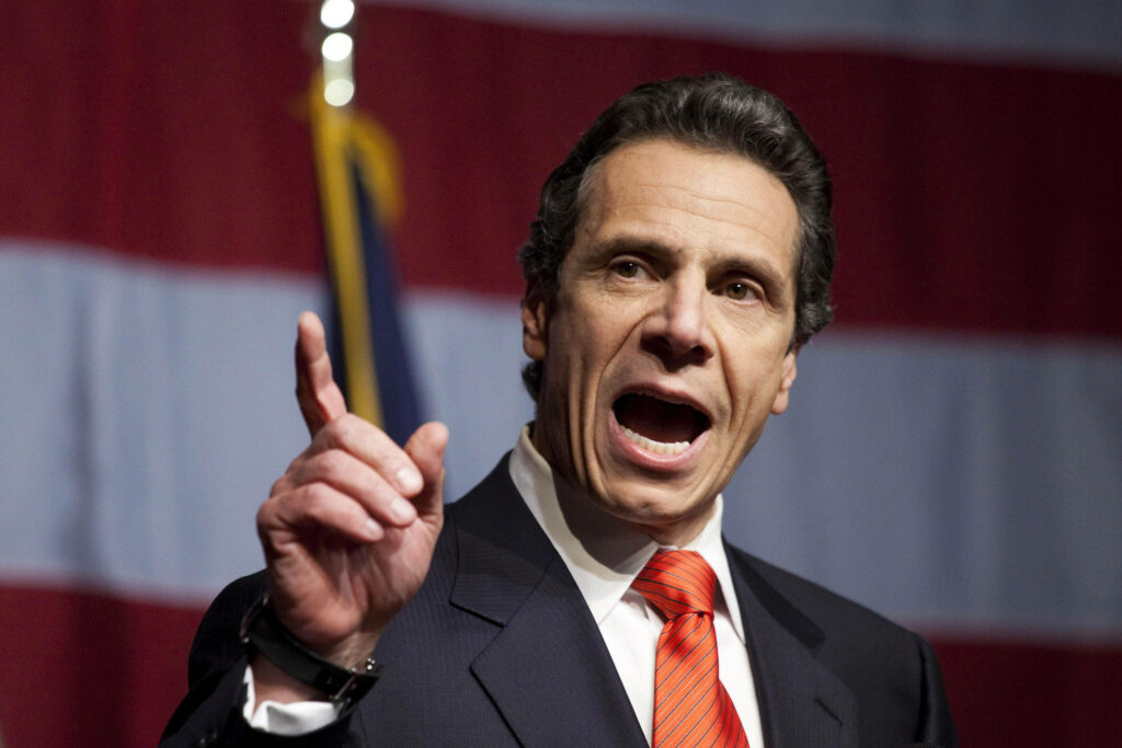Andrew Cuomo delivering passionate speech with American flag backdrop leadership wallpaper