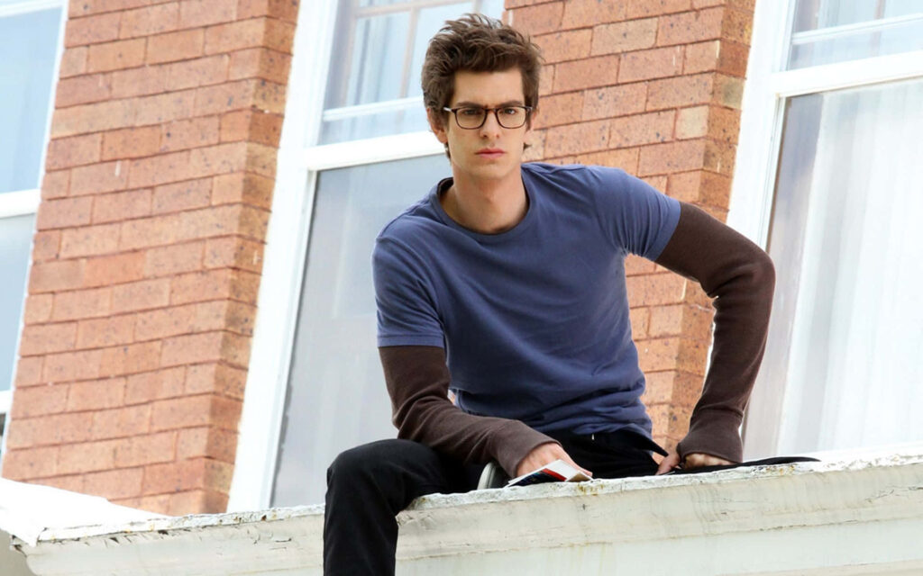 Andrew Garfield sitting on rooftop casual outfit focused gaze wallpaper background