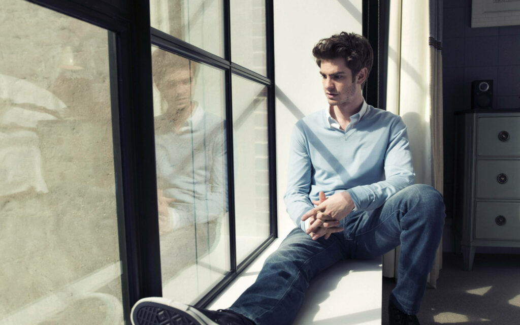 Andrew Garfield thoughtful by window calm introspective mood The Social Network wallpaper background