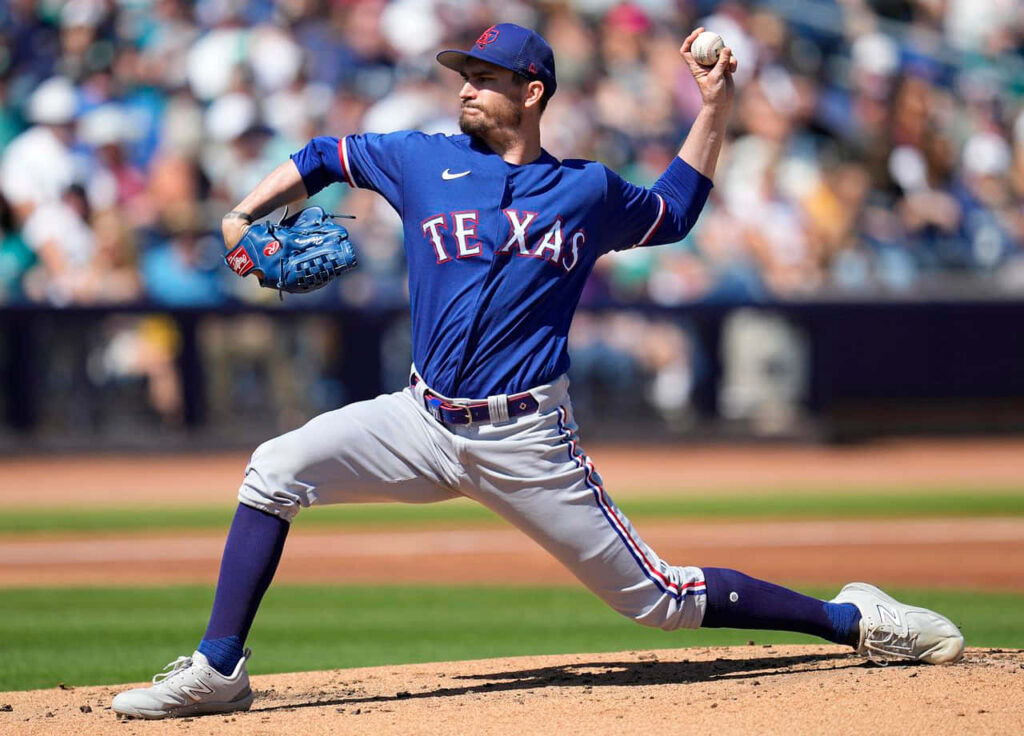 Texas pitcher Andrew Heaney delivering a powerful pitch showing focus and athleticism on mound Wallpaper