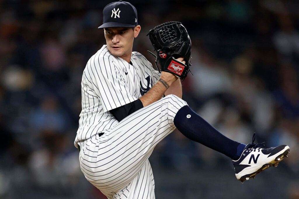 Andrew Heaney pitching in Yankees pinstripe uniform mid-windup during baseball game wallpaper