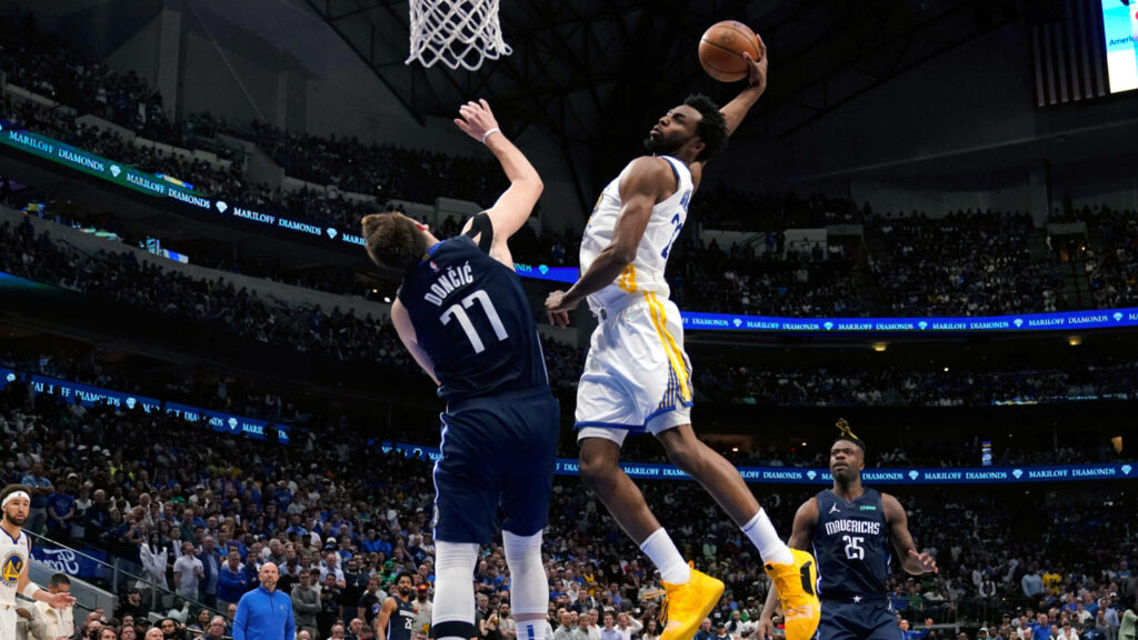 Andrew Wiggins dunks over Luka Doncic in an intense NBA game thrilling basketball fans wallpaper