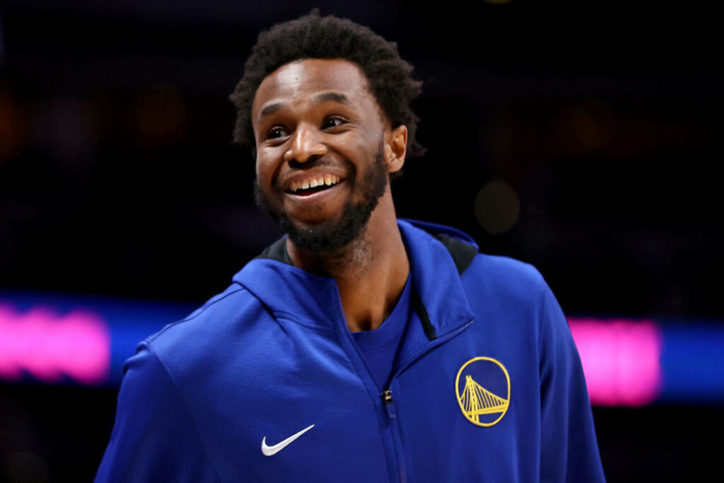Andrew Wiggins smiling in Golden State Warriors warm-up jacket basketball court wallpaper background
