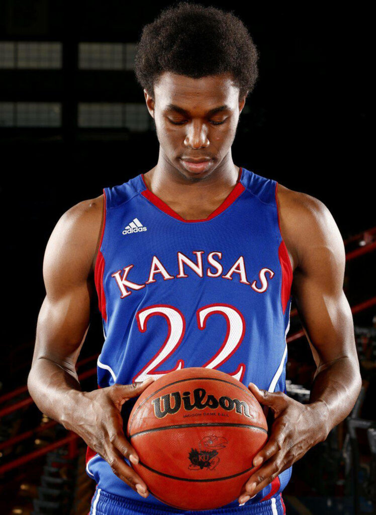 Andrew Wiggins in Kansas Jayhawks uniform holding basketball showing focus and determination Wallpaper