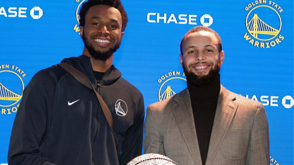 Andrew Wiggins and Stephen Curry pose united in front of Golden State Warriors backdrop wallpaper