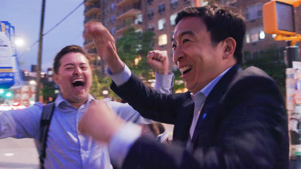 Andrew Yang laughing joyfully outdoors urban setting celebrating positivity wallpaper background