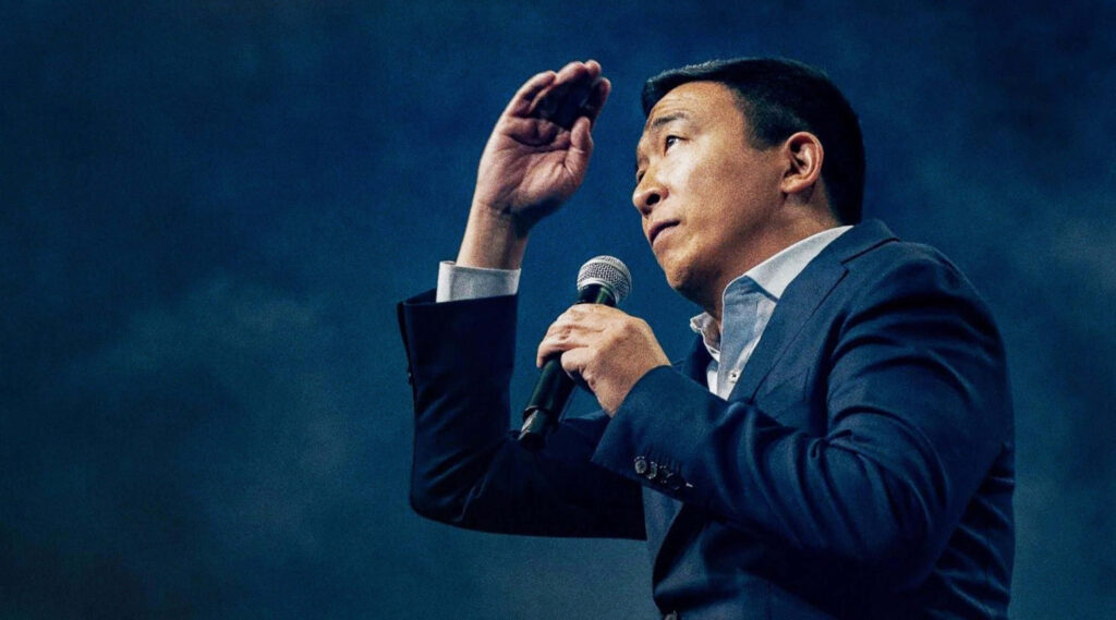 Andrew Yang speaking passionately about Universal Basic Income holding microphone gesturing Wallpaper