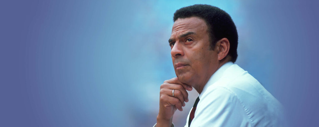 Portrait of civil rights leader Andrew Young with thoughtful expression on blue wallpaper background