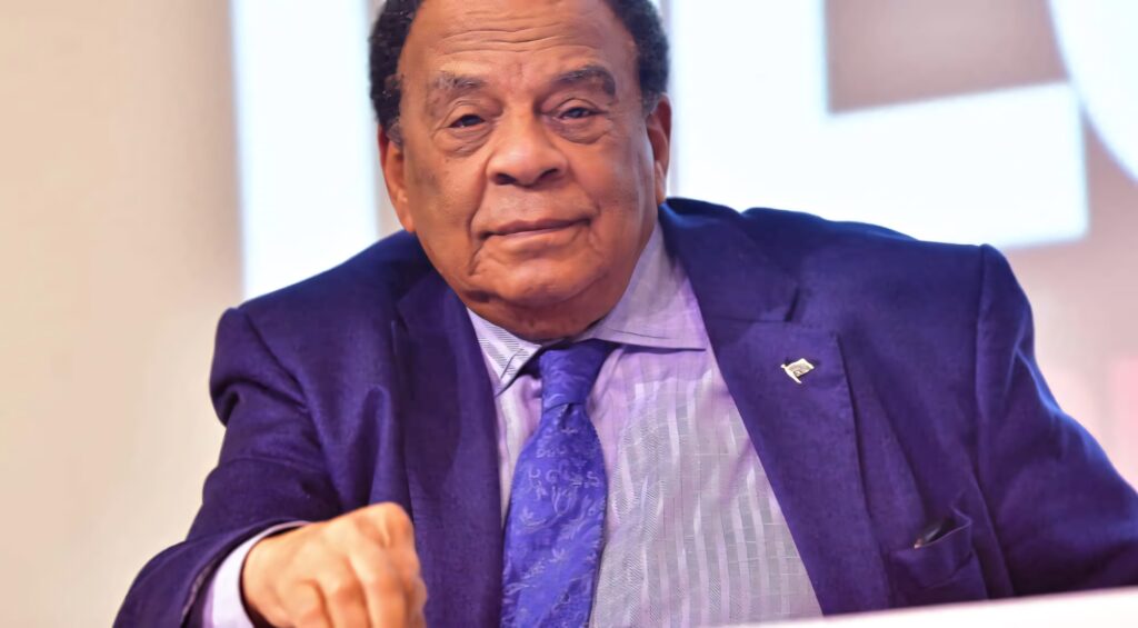 Andrew Young smiling in sharp blue suit and light patterned shirt professional portrait wallpaper