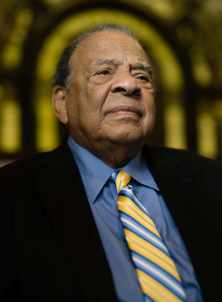 Andrew Young thoughtful reflection inside church with stained glass windows and soft lighting Wallpaper
