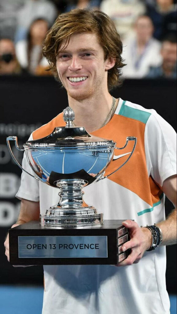 Andrey Rublev holding Open 13 Provence trophy celebrating tennis victory on court wallpaper