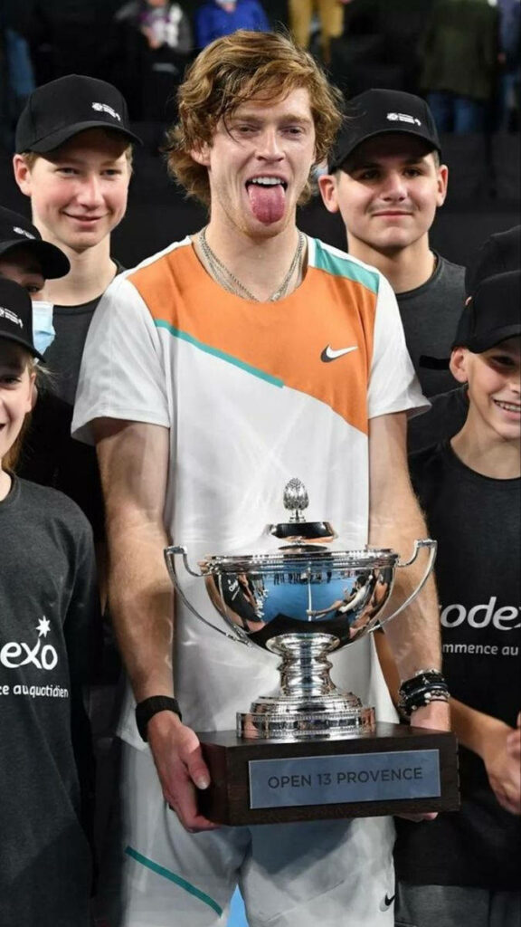 Andrey Rublev celebrates Open 13 Provence trophy win with joyful fans on tennis court wallpaper background