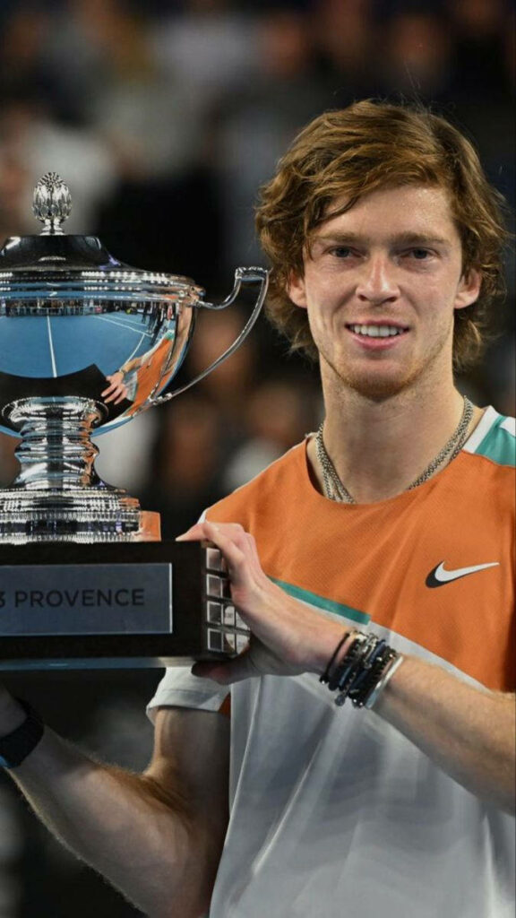 Andrey Rublev holding silver trophy smiling celebrating tennis victory dynamic wallpaper background