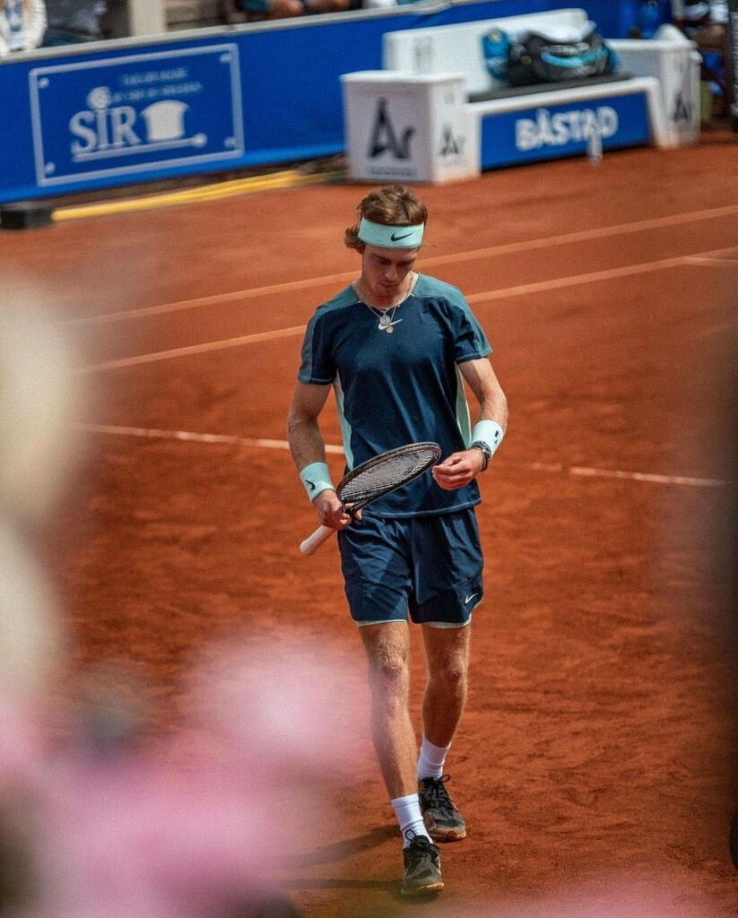 Andrey Rublev walking focused on clay tennis court ready for next move dynamic wallpaper background