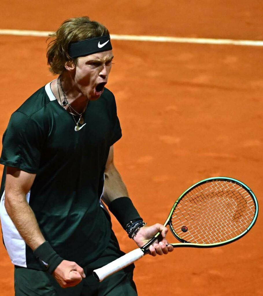 Andrey Rublev yelling passionately on clay tennis court gripping racquet intense emotion wallpaper