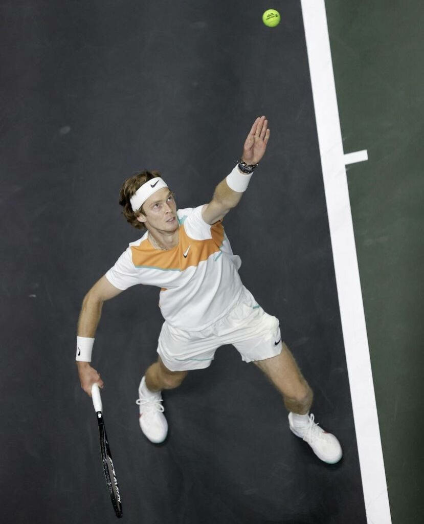 Birds eye view of tennis player Andrey Rublev serving showcasing athletic form and focus wallpaper
