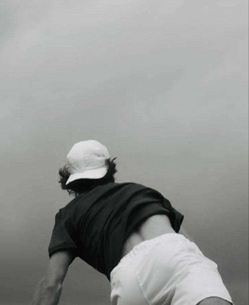 Monochrome wallpaper of tennis star Andrey Rublev in dynamic motion with dramatic sky background