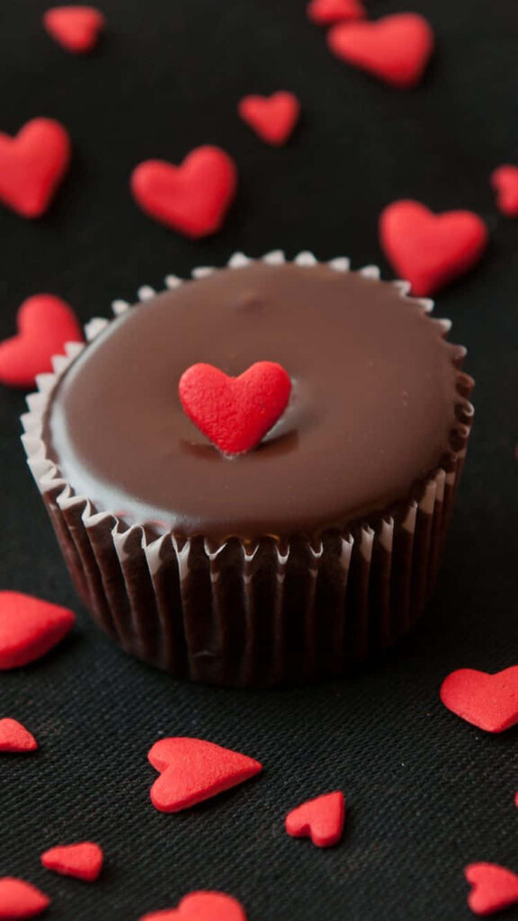 Sweet Love: An Irresistible Chocolate Cupcake Surrounded by Symbolic Hearts in an Desserts Wonderland Wallpaper