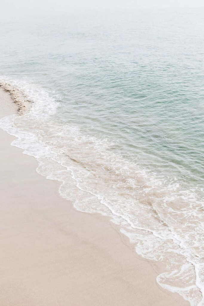 Aerial view of Malibu's pristine beach with its sandy coast and crystal-clear water Wallpaper