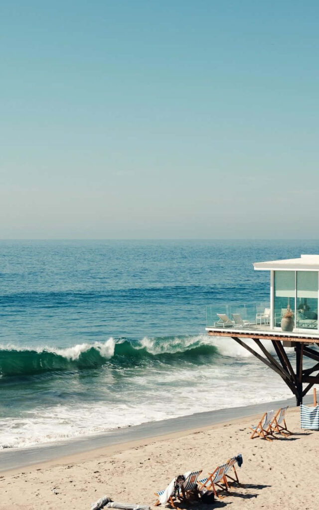 Coastal Retreat: Wallpaper with Stunning Beachfront Mansion Showcasing Majestic Ocean Views