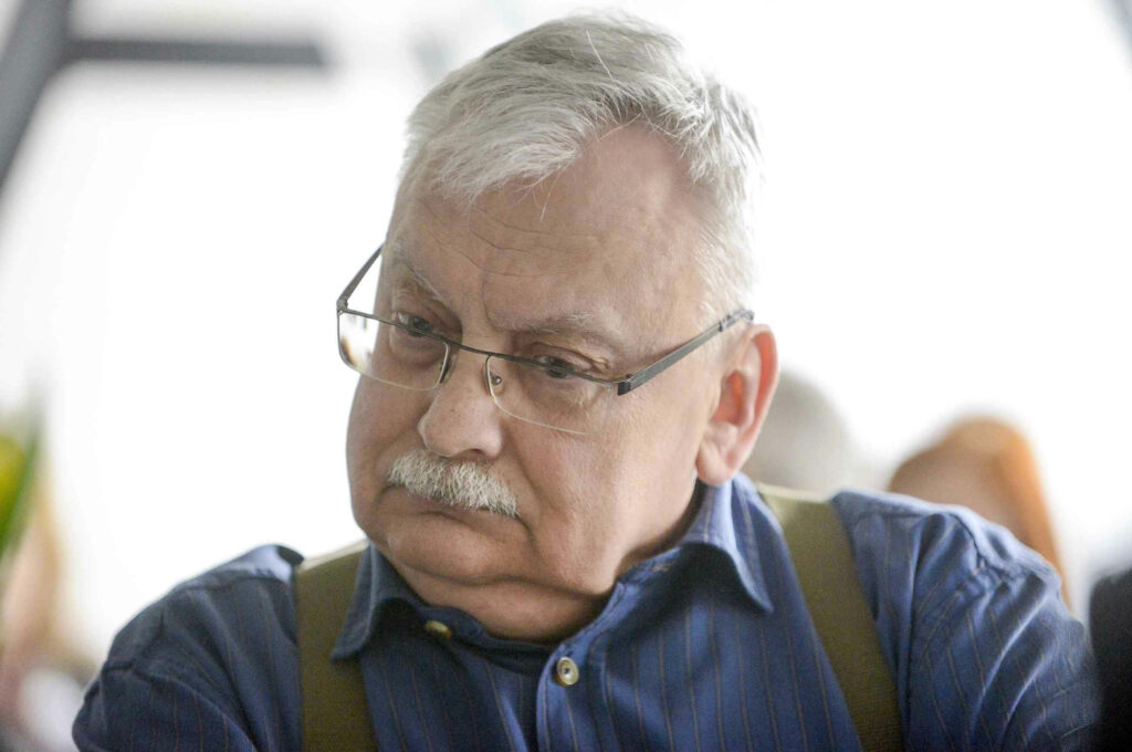 Thoughtful portrait of Andrzej Sapkowski creator of The Witcher series inspiring fantasy fans wallpaper