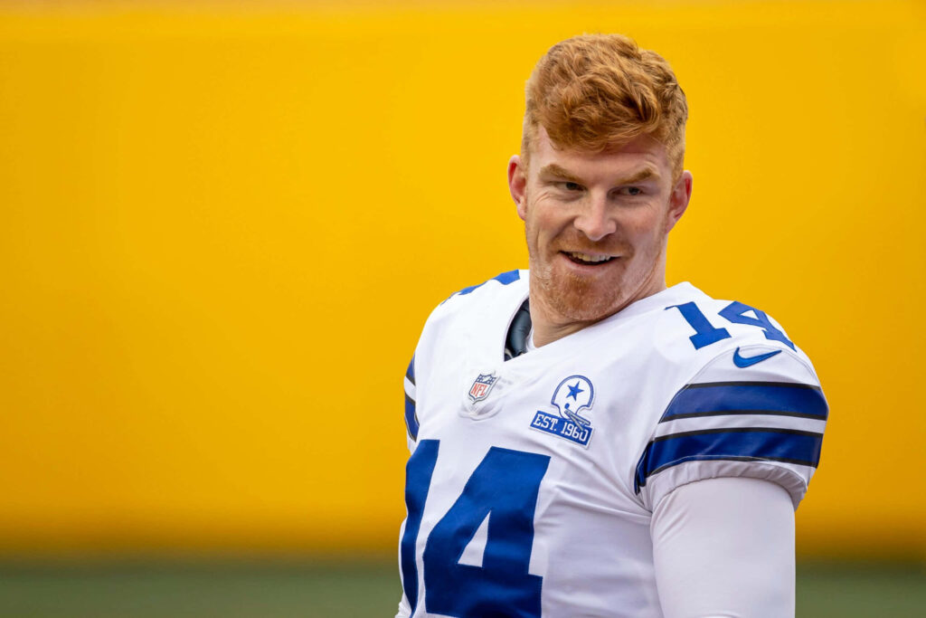 Smiling quarterback Andy Dalton in Dallas Cowboys uniform on bright yellow background wallpaper