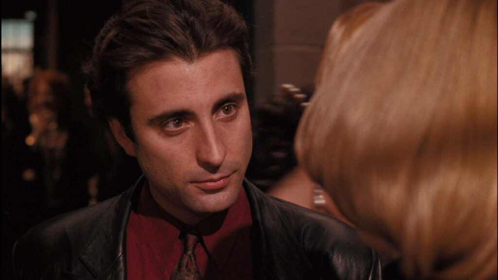 Andy Garcia in dark jacket and red shirt in intense scene from The Godfather Part III wallpaper